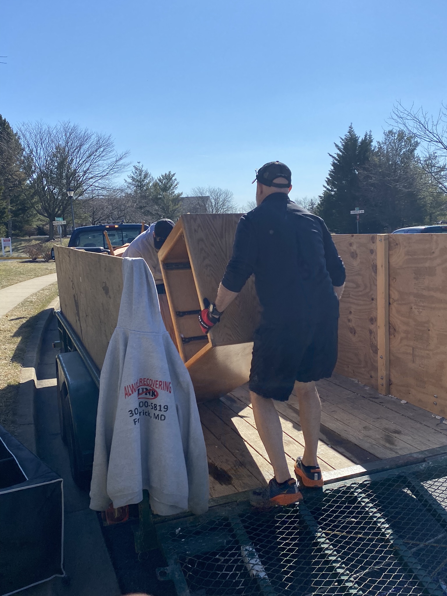 One of our team members loading a piece of furniture onto our trailer during junk removal services in rockville md