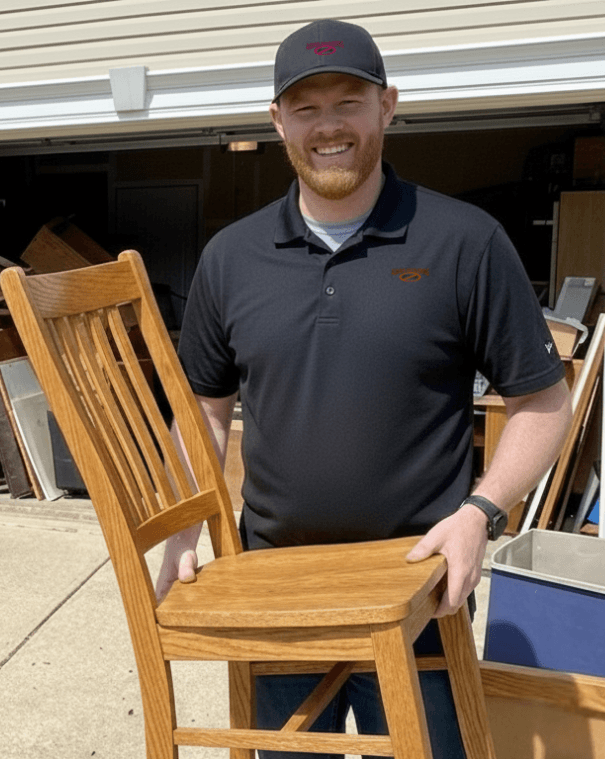 junk removal employee holding a dining chair